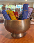 Second view of colorful Tibetan prayer flags in a brass bowl