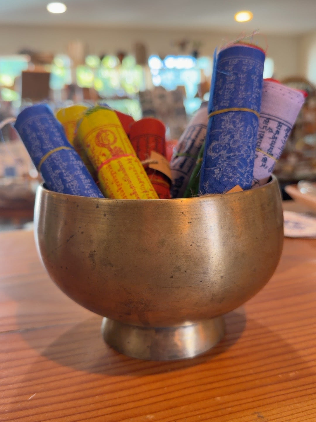 Second view of colorful Tibetan prayer flags in a brass bowl
